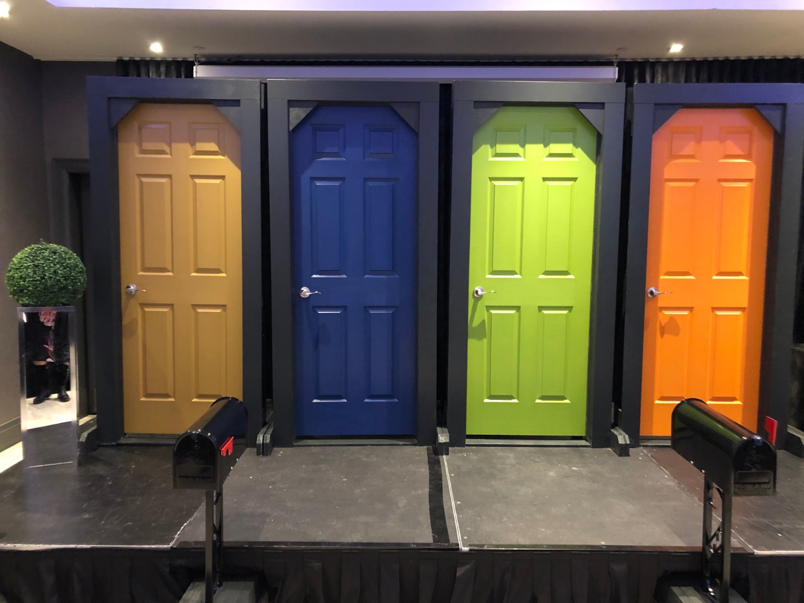Four brightly coloured doors on stage used to role-play door knocking for different personality types